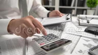 在办公室工作和计算财务的商人，阅读和写报告。 商业财务会计概念